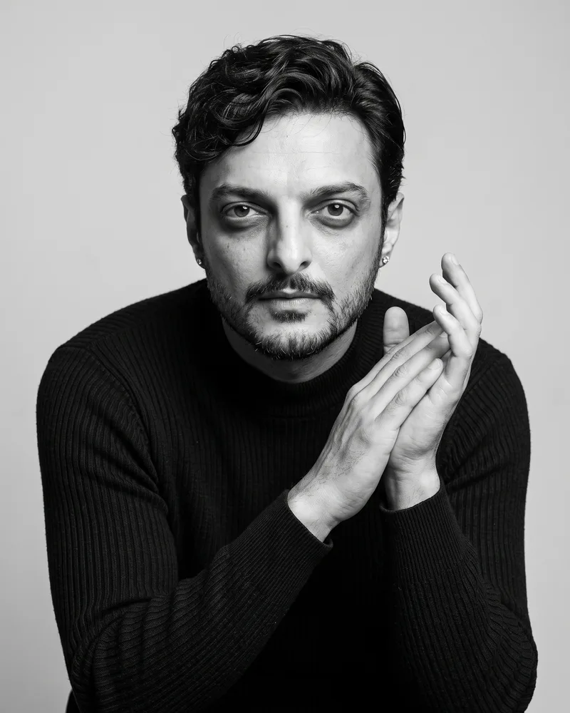 Syed Irtiza, co-founder and art director of Creative Frog, in a black ribbed sweater with hands pressed together